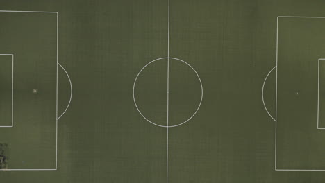Vista-De-Arriba-Hacia-Abajo-De-Un-Campo-De-Fútbol-Verde-Y-Vacío-En-Medio-Del-Bosque,-Imágenes-De-Drones