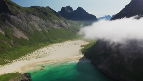 Cinematic-aerial-shot-of-Horseid-Beach-with-turquoise-blue-water,-clouds-moving-over-cliffs,-descending-to-isolated-beach