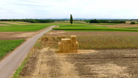 Fly-Over-Natural-Haystack-With-Dry-Square-Straw-Over-Countryside-Fields