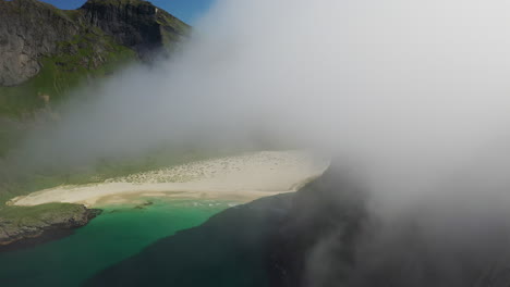 Cinematic-drone-shot-of-Horseid-Beach-with-turquoise-blue-water,-flying-through-the-clouds