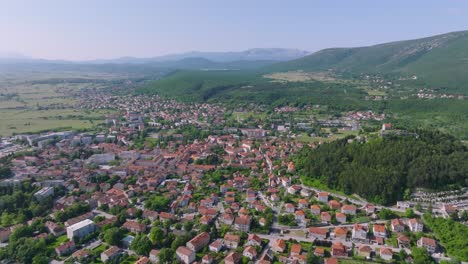A-smooth-arcing-shot-high-above-the-city-of-SInj,-Croatia-on-a-bright-clear-day