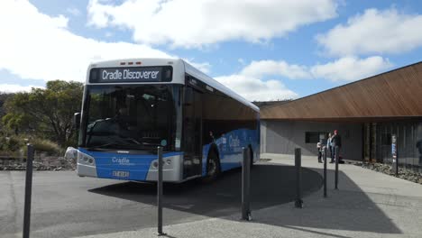 Shuttle-bus-drives-around-turning-circle-at-visitor-centre-in-Cradle-Mountain-Tasmania-on-bright-day