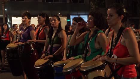 Female-protester-percussion-band-perform-on-streets-of-Buenos-Aires-for-women's-rights,-woman-looks-at-camera