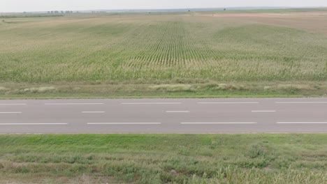 Fahrzeuge-Fahren-Auf-Der-Landstraße-Zwischen-Landwirtschaftlichen-Feldern-In-Domnesti,-Rumänien-–-Statisch
