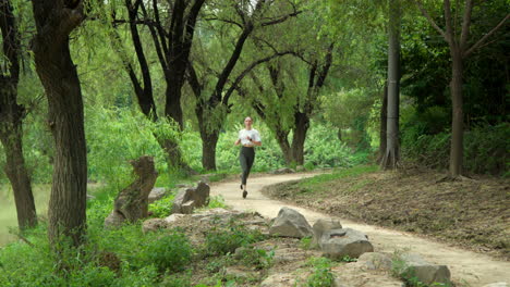 Mujer-Joven-En-Forma-Corriendo-En-Un-Parque-Junto-Al-Río-En-Cámara-Lenta