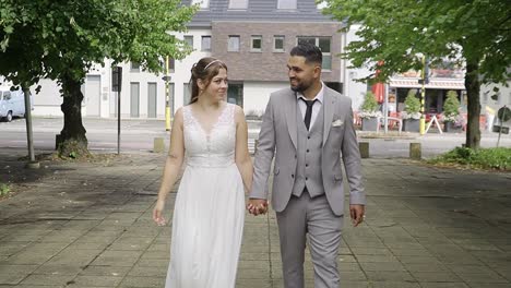 Pareja-De-Recién-Casados-Caminando-Mientras-Se-Toman-De-La-Mano-En-El-Entorno-Urbano