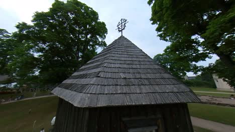 Metal-Cross-On-A-Wooden-Building-Next-To-The-Church-In-Kernave,-Lithuania