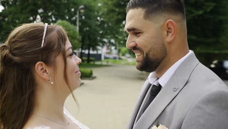 Romantic-portrait-shot-of-young-newlywed-couple-looking-in-each-others-eyes-and-smiling