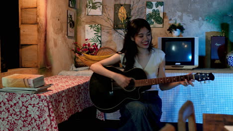 Chica-Asiática-Tocando-La-Guitarra-En-Casa,-Estática.