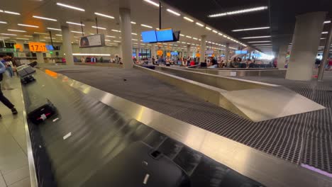Rolling-luggage-belt-with-suitcases-and-bags-at-Schiphol-Airport-Amsterdam