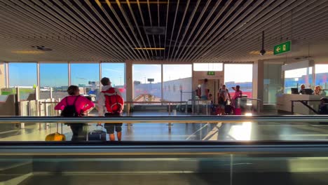 Menschen,-Die-Auf-Dem-Weg-Zu-Ihrem-Flugzeug-Auf-Einem-Laufband-Am-Flughafen-Schiphol-Laufen