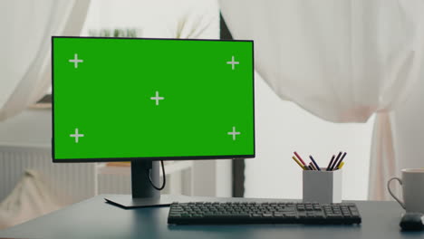 Powerful-computer-with-chroma-key-green-screen-mock-up-stands-on-desk