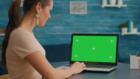 Business-woman-looking-at-laptop-display-with-mock-up-green-screen