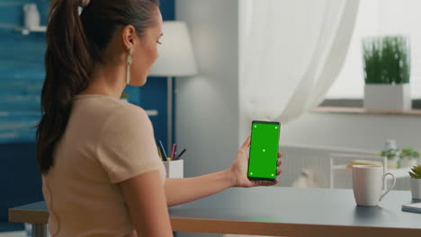 Social-media-woman-holding-touchscreen-phone-with-mock-up-green-screen