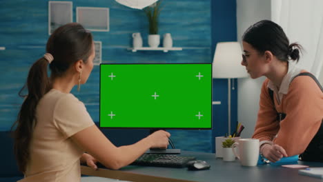 Two-friends-sitting-in-front-of-mock-up-computer-green-screen