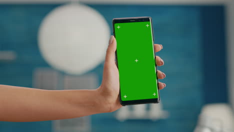 Hands-of-freelencer-holding-vertical-mock-up-green-screen-chroma-key-smartphone