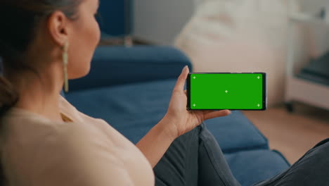 Close-up-of-woman-holding-smartphone-with-mock-up-green-screen-chroma-key-display