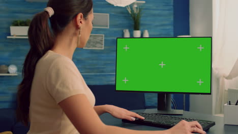 Business-woman-browsing-on-computer-with-mock-up-green-screen-chroma-key-display