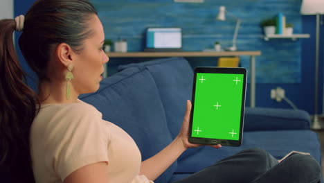 Freelancer-woman-looking-at-green-mock-up-screen-tablet-computer