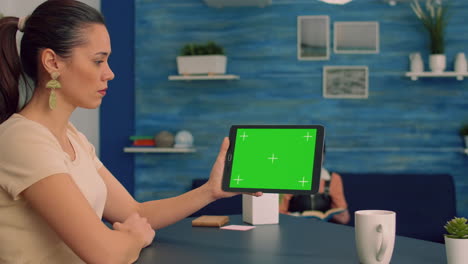 Caucasian-female-looking-at-tablet-computer-with-mock-up-green-screen-for-online-.advertising