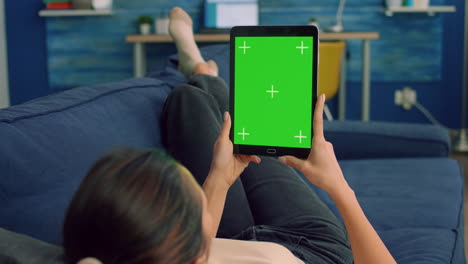 Lässige-Frau,-Die-Auf-Dem-Sofa-Liegt-Und-Einen-Tablet-Computer-Mit-Grünem-Bildschirm-Verwendet