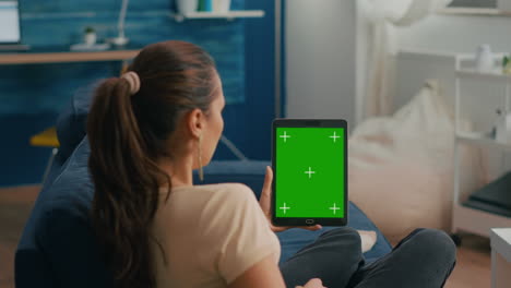 Business-woman-looking-at-tablet-computer-with-mock-up-green-screen-chroma-key-display