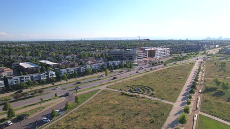 Aerial-Drone-reverse-flyover-of-Park-in-Denver-Colorado-with-neighborhood-and-construction-in-the-back-ground-Stapleton,-Colorado