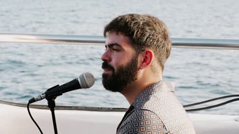 Mann-Singt-Durch-Ein-Mikrofon-Auf-Einem-Katamaran-Segelboot