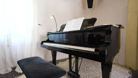 Slow-push-in-revealing-a-gloss-black-baby-grand-piano-with-sheet-music-on-top
