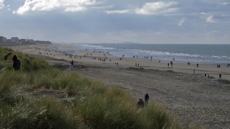 People-enjoying-autumn-day-at-Oostduinkerke-beach,-Belgium