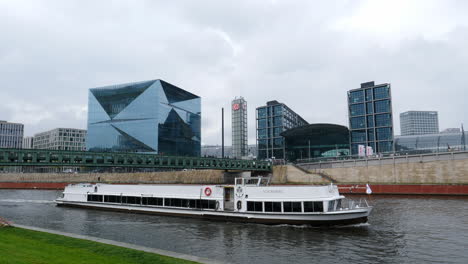 Berlin-Central-Station-and-The-Cube,-boat-sailing-in-foreground,-Germany