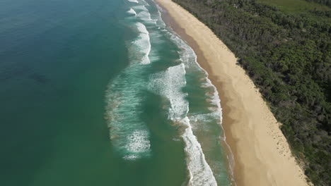 Aerial-tilt-up-shot-of-with-ocean-and-waves-near-Cape-Conran-Coastal-Park,-Australia