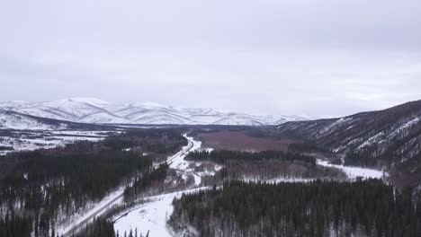 Aerial-Alaska-Wilderness-Landscape,-Snow-Covered-Hills,-Green-Spruce