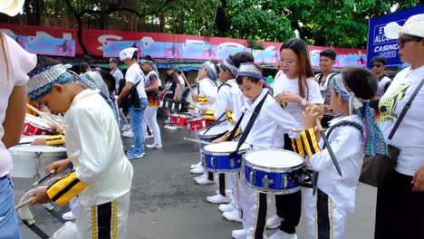 A-group-of-young-Filipino-children-accompanied-by-their-parents-stood-on-the-road-for-a-parade-presentation-during-the-Davao-City-festival