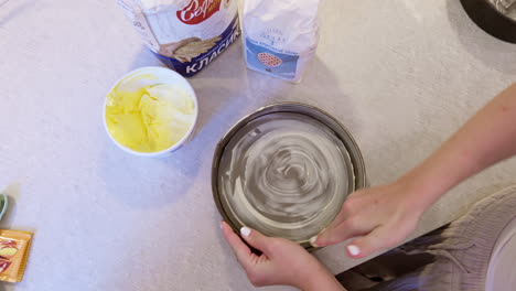 Pastelero-Engrasa-Estaño-Con-Las-Manos-Desnudas-En-La-Encimera-De-La-Cocina,-Vista-De-Arriba-Hacia-Abajo