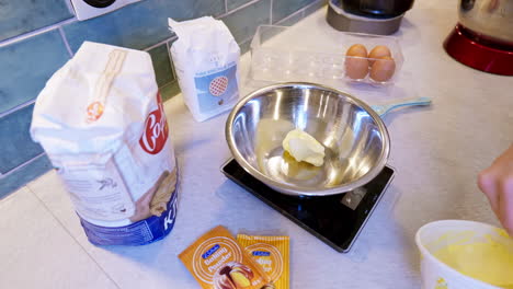 El-Cocinero-Casero-Pesa-La-Mantequilla-En-Un-Tazón-Mientras-Se-Prepara-Para-Hornear-Pasteles.