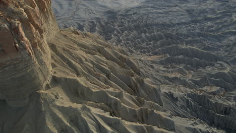 Drone-Shot-of-Moonlike-Landscape,-Dry-Desert-Land-and-Hills-Under-Factory-Butte,-Utah-USA