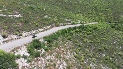 Toma-De-Drone-De-Un-Vehículo-ATV-De-Cuatro-Ruedas-Moviéndose-Por-La-Carretera-En-El-Campo-De-La-Isla-De-Zakynthos,-Grecia