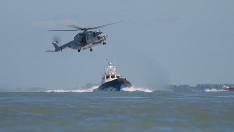 Diver-on-Winch-Beneath-NH-90-Navy-Helicopter-Flying-Above-Lifeboat