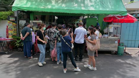 Clientes-Haciendo-Cola-Y-Esperando-Sus-Pedidos-De-La-Famosa-Ensalada-Tailandesa-De-Papaya,-Con-Cerdo-Y-Pollo-A-La-Parrilla-Servidos-En-Las-Calles-De-Bangkok.