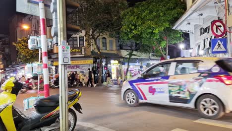 Una-Escena-Callejera-Típica-Con-Tráfico-Urbano-En-Hanoi,-Vietnam,-Durante-La-Noche.