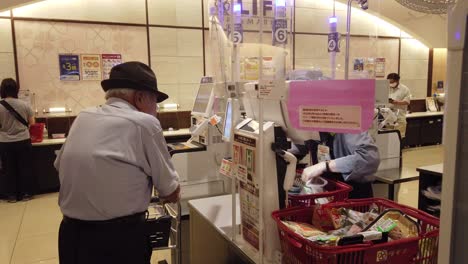 Japanischer-älterer-Mann-Zahlt-Essen,-Supermarktkassierer,-Japanisches-Inflationspreiskonzept
