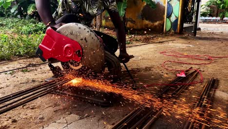 Worker-cut-steel-with-cutting-machine-circular-disc-cuts-off-part-of-iron-until-sparks-occur-while-cutting-steel