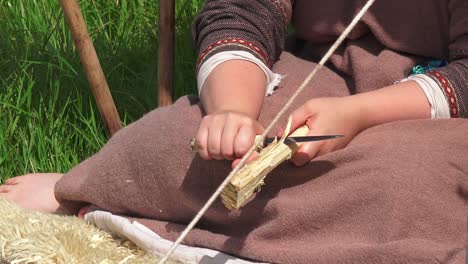 Recreación-Vikinga-Mujer-Tallando-Madera-Para-Hacer-Herramientas-De-Cocina-En-Waterford,-Irlanda