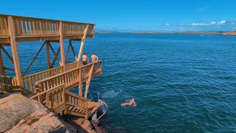 Nadadores-Utilizando-La-Nueva-Torre-De-Salto-De-Madera-En-Lysekil,-Suecia