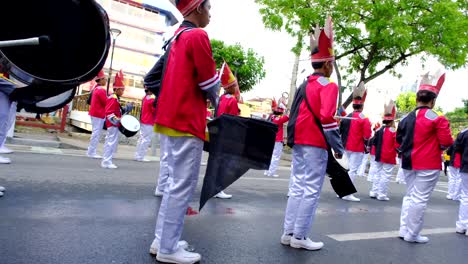 Gruppe-Von-Männern-In-Rot-weißen-Uniformen-Mit-Musikalischen-Trommelinstrumenten-Auf-Einer-Straßenparade