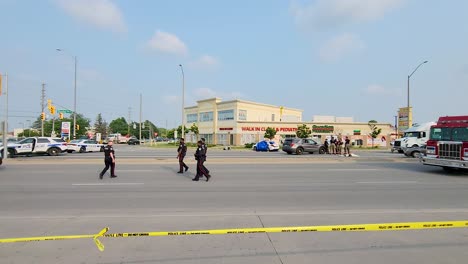 Pan-shot-follow-police-officers-walking-on-crime-scene-blocked-area-from-car-accident