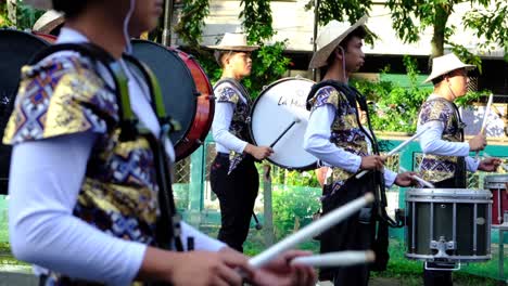 Grupo-De-Jóvenes-Músicos-Tocando-Música-Con-Tambores-En-Formación-De-Desfile-Callejero