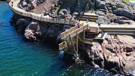 Swimmers-using-the-new-wooden-jump-tower-in-Lysekil,-Sweden