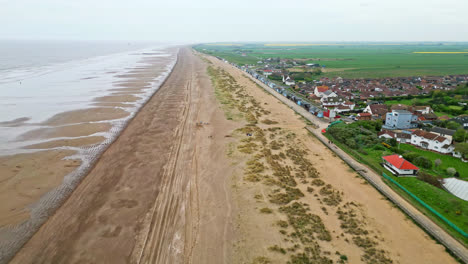 Aerial-footage-brings-Mablethorpe-to-life,-highlighting-beach-huts,-sandy-beaches,-amusement-parks,-rides,-and-the-joyful-tourist-atmosphere